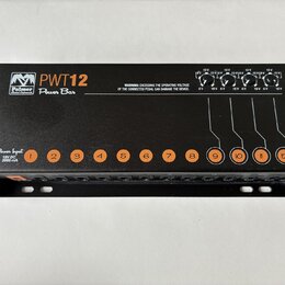 Černý napájecí adaptér pro pedály s nápisem Palmer PWT12 Power Bar. Zařízení obsahuje dvanáct očíslovaných výstupů a vstup označený jako Power Input…