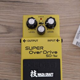 Žlutý kytarový efekt s nápisy SUPER Over Drive SD-1w a logem BOSS. Na horní části jsou tři bílé ovládací knoflíky s popisky LEVEL a DRIVE, přepínač S…