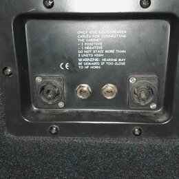 Detail zadní strany reproduktorové skříně s černým povrchem. Jsou zde dva konektory pro připojení kabelů a nápis: ONLY USE LOUDSPEAKER CABLES FOR CON…