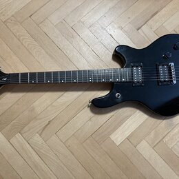 Černá elektrická kytara s dvojstupňovými humbuckery a fixním mostem. Na hlavě je bílý nápis Washburne a označení modelu BF-2. Nástroj vykazuje mírné…