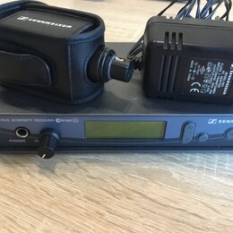 Černý přijímač s nápisem TRUE DIVERSITY RECEIVER GW500 G2 a logem SENNHEISER. Na přístroji je umístěn černý adaptér s nápisem SENNHEISER MODEL G 2347…