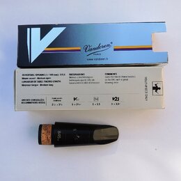 Na fotografii je černý mouthpiece s korkovým nátrubkem, doprovázený původním kartonovým obalem a modrou papírovou krabičkou. Na mouthpiece je vyryto…