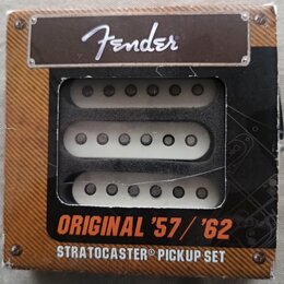 Sada tří bílých snímačů pro kytaru v originálním kartonovém obalu. Na horní části je logo Fender a ve spodní části nápisy ORIGINAL '57 / '62 STRATOCA…
