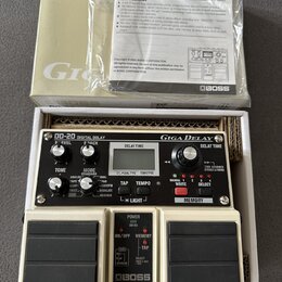 Bílá kytarový efekt Boss DD-20 Giga Delay v originálním obalu s přiloženým manuálem. Na zařízení jsou viditelné nápisy DD-20 DIGITAL DELAY, Giga Dela…