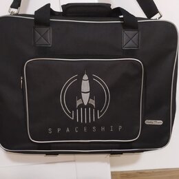 Černá látková přepravní taška s bílým lemováním hran. Na přední straně je bílý potisk rakety v kruhu a pod ním nápis SPACESHIP. V pravém dolním rohu…