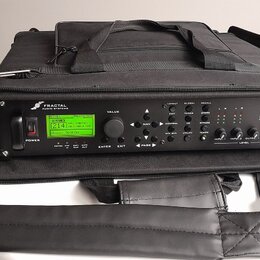 Černý rackový procesor v černé přepravní tašce s popruhem. Na předním panelu je zelený LCD displej a nápisy FRACTAL AUDIO SYSTEMS oraz Axe-Fx ULTRA.…