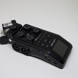 Černý digitální nahrávač značky ZOOM s modelem H6 handy Recorder. Zařízení má integrovaný displej, ovládací tlačítka a několik regulačních knoflíků.…