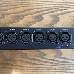 Černý rackový panel s šesti vstupními konektory XLR. Nad každým konektorem je bílý nápis od INPUT 11 do INPUT 16. V pravé dolní části je fialový troj…