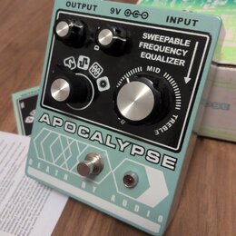 Světle modrý kytarový efekt s černým ovládacím panelem. Na panelu jsou čtyři kovové otočné knoflíky a nápisy OUTPUT, 9V, INPUT a SWEEPABLE FREQUENCY…