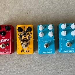 Čtyři kytarové efekty v řadě. Zleva: červený pedal s nápisy m:fuzz, Caïne a CLASSIC FUZZ; žlutý pedal s nápisem FUZZ a logem Caïne; modrý pedal s náp…
