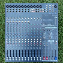 Šedý mixovací pult značky YAMAHA s označením modelu EMX5016cF. Zařízení obsahuje více vstupních kanálů s posuvníky, řadu otočných knoflíků v různých…