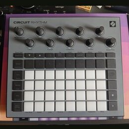 Šedý sekvenční sampler s názvem CIRCUIT RHYTHM a logem Novation v pravém horním rohu. Zařízení obsahuje několik otočných knoflíků, řadu malých tlačít…