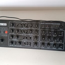 Černý analogový syntetizátor s nápisy Pro-800 a behringer. Přístroj obsahuje početné otočné knoflíky, tlačítka s čísly 0–9 a různé ovládací sekce jak…