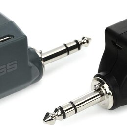 Dvě bezdrátové vysílače/přijímače značky BOSS s konektory typu jack. Levý je šedý a nese nápisy MODEL: WL-20L, MADE IN CHINA, CE oraz přepínače POWER…