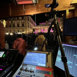 Fotografie zachycuje zvukovou režií s mixážním pultem, dvěma monitory a stativem s kamerou. Na pultu je viditelný nápis Quartz a logo AZ-MUSIC. V poz…