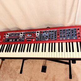 Červený digitální klavír Nord Stage 3 umístěný na černém stojanu. Na levé straně je bílý nápis nord Stage 3 a pod ním menší text ORGAN PIANO SYNTH SE…