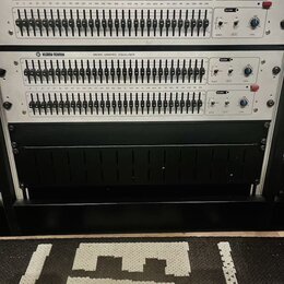 Dvě identické rackové jednotky s nápisem KLARK-TEKNIK DN360 GRAPHIC EQUALISER. Každý přístroj má dvě řady posuvníků s označením kmitočtů od 25 do 20k…