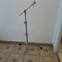 Stříbrný kovový stativ s teleskopickým stojanem a nastavitelní ramenem. Na konci ramene je umístěn černý držák. Povrch kovových částí je lesklý, bez…