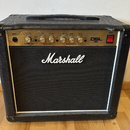 Kytarový kombo zesilovač značky Marshall, model DSL 5C. Má černý texturovaný povrch a černé textilní krytí reproduktoru s bílým rámečkem. Na horním o…