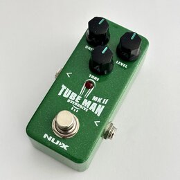 Zelený kytarový efekt s nápisem TUBE MAN MK II OVERDRIVE. Na horní straně jsou tři černé otočné ovířky s popisky DRIVE, TONE a LEVEL. V dolní části j…