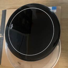 Černý bubnový kožen s bílým kruhem v horní části, na kterém je bílé logo REMO. Pod ním je vidět druhý, průsvitný bubnový kožen s malým logem REMO. Ce…