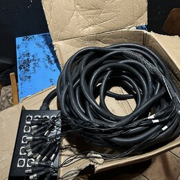 Černá stagebox s osmi vstupy XLR, ze kterých vychází svazek černých kabelů. V horní části stageboxu jsou viditelné nápisy 1 až 8 u jednotlivých vstup…