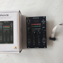 Černý modul Eurorack s nápisem BRAINS a logem behringer. Na předním panelu jsou knofíky, přepínače, OLED displej a výstupy OUT 1 a OUT 2. Vedle modul…