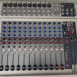 Stříbrný mixážní pult s modrými a červenými ovratovými knoflíky. V pravém horním rohu je nápis PV14 USB a v pravém dolním rohu logo Peavey. Zařízení…