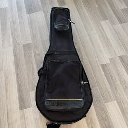 Černý polštovaný pouzdro na kytaru s přední kapsou a horním úložným prostorem. V dolní části je umístěno logo ROCKCASE s žlutým pruhem. Povrch látky…
