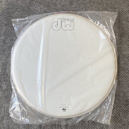 Bílá bubnová blána v originálním plastovém obalu. V horní části je černé logo „drums dw“. Ve spodní části jsou nápisy „EVOLT“, „SHELL TECHNOLOGY“ a l…