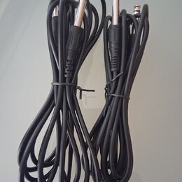 Dvě černé kábely s konektory typu jack na obou koncích. Káble jsou svázány černými stahovacími pásky. Na kablech nejsou viditelné žádné značky ani ná…