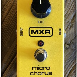 Žlutý kytarový efekt s nápisem MXR a označením micro chorus. Na horní straně je černý otočný knoflík s popiskem RATE. V horní části jsou vidět vstupy…