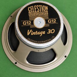 Kruhový reproduktor s béžovým kovovým rámem a černou membránou. Na černé středové krytce je zlatý nápis CELESTION LOUDSPEAKERS, dvakrát označení G12…