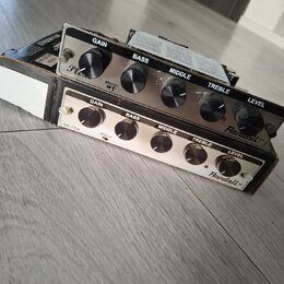 Dvě kytarové zesilovače s kovovým předním panelem a černými ovládacími knoflíky. Horní jednotka má nápisy GAIN, BASS, MIDDLE, TREBLE, LEVEL a logo Ra…