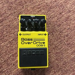 Žlutý kytarový efekt Boss Bass OverDrive ODB-3. Na horní straně jsou čtyři černé ovládací knoflíky s popisky MIN MAX, CUT BOOST (s přepínačem HIGH LO…
