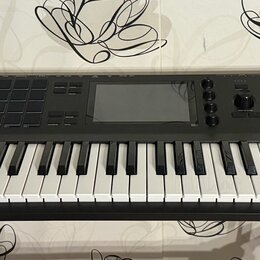 Černý klaviatura MPC s bílými a černými klávesami, umístěná na černém stojanu. Na pravé straně je bílý nápis AKAI PROFESSIONAL a pod ním MPC KEY 61.…