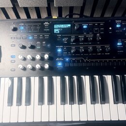 Šedý syntetizátor s klaviatura značky KORG, na jehož pravé straně je nápis wavestate. Přístroj disponuje displejem, několika posuvníky, otočnými knof…