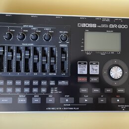 Stříbrnošedý digitální nahrávač s černým ovládacím panelem. Na horní části je nápis BOSS DIGITAL RECORDER BR-800 a LCD displej. Přístroj obsahuje něk…