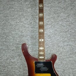 Elektrická kytara s tělem v barvě sunburst a hnědým hnedkem. Na hlavě je bílý nápis jolana a vedle něj menší text 3-55. Kytara má černý pickguard, dv…