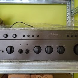 Šedý stereo zesilovač s nápisem Technics Stereo Integrated Amplifier SU-8080. Přední panel obsahuje několik otočných ovladačů, tlačítek a přepínačů s…