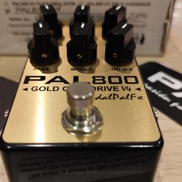Kytarový efekt pedál s zlatým horním panelem a černým šasi. Na povrchu je nápis PAL800, GOLD Overdrive V4 a dalPalfx. Pedál má tři černé kontrolní kn…
