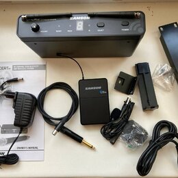 Sada bezdrátového systému značky SAMSON. Obsahuje černý přijímač s nápisem CR 88 UHF WIRELESS RECEIVER, malý černý vysílač s nápisem SAMSON CR 88 a p…