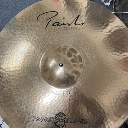 Kladivovaná mosazná činely s nápisem Paiste a pod ním menším REFLECTOR. Ve spodní části je uveden model Bell Ride 22" a logo POWER SLAVE s motivem le…