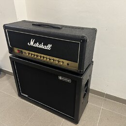 Kytarový zesilovač Marshall DSL umístěný na kytarovém cabinetu značky revoltage. Horní kombo má černý texturovaný povrch, zlatý ovládací panel a bílé…
