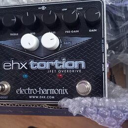 Kytarový efekt v černé barvě s kovovým povrchem a nápisem ehx torsion JFET OVERDRIVE. Na spodní části je uveden výrobce electro-harmonix a web WWW.EH…