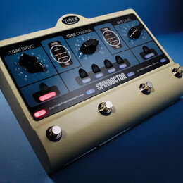 Kremově bílý kytarový pedál s nápisem SPINDOCTOR a logem T-REX. Zařízení obsahuje ovládací knoflíky pro sekce TUBE DRIVE, TONE CONTROL a OUT LEVEL, p…