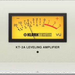 Bílý rackový přístroj s nápisem KT-2A LEVELING AMPLIFIER a logem KLARKTEKNIK. Na předním panelu se nachází VU metr, tři černé otočné ovratidla s popi…