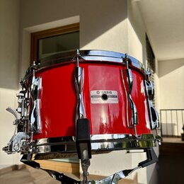 Červený buben s chromovaným obručováním a úchytky, umístěný na kovovém stojanu. Na korpusu je viditelný štítek s nápisy YAMAHA, MODEL NO. 503 a SER.…