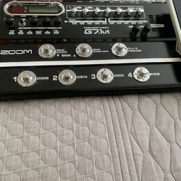 Černý kytarový procesor s nápisem GUITAR EFFECTS CONSOLE G2.1ut a logem ZOOM. Zařízení má digitální displej, několik ovládacích knoflíků a čtyři stou…