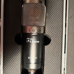 Kondenzátorový mikrofon v černém kufru s pěnovou výplní. Na těle je bílý nápis „the t.bone“ a níže označení modelu „SC-100“. V horní části je vidět s…